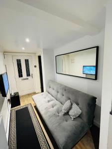 ein Wohnzimmer mit einem Sofa und einem Spiegel in der Unterkunft Exclusive Private One Bedroom Suite in London