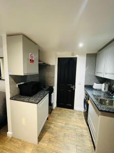 a small kitchen with a sink and a counter top at Exclusive Private One Bedroom Suite in London