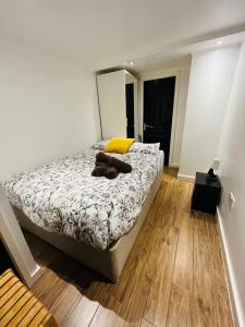 a bedroom with a bed with a yellow pillow and a mirror at Exclusive Private One Bedroom Suite in London