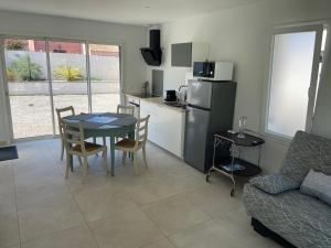 uma cozinha e sala de estar com uma mesa e um sofá em JOLIE MAISON A 700M DE LA MER em Le Grau-dʼAgde