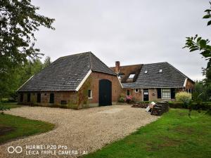 a brick house with a black door and a yard at The nicest farmhouse in Holland! in Epse