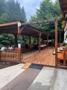 a large wooden deck with people sitting on it at Barlogul din Vidraru in Curtea de Argeş