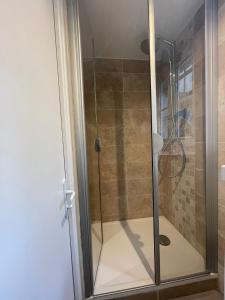 een douche met een glazen deur in de badkamer bij Heart of Paris Apartment in Parijs