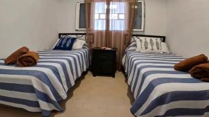 twee bedden naast elkaar in een kamer bij Apartamento Tierra, Primera línea Mar in Playa Honda