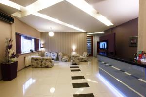 a lobby with a pool and chairs and a tv at Hotel Centar in Skopje