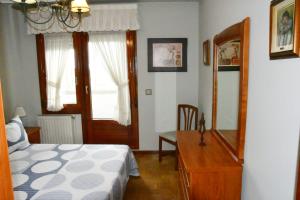 a bedroom with a bed and a dresser and a mirror at Puerta la Villa in Avilés