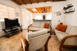 un soggiorno con divani e TV a schermo piatto di Casa Isabel a Rincon