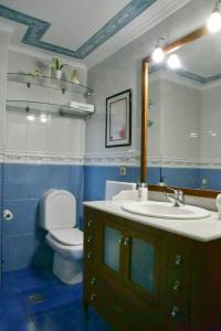 a bathroom with a sink and a toilet and a mirror at Puerta la Villa in Avilés