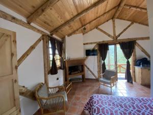 a bedroom with a bed and chairs in a room at The Hideout- A Cabin in Nature; 25 min from Cuenca in Cuenca