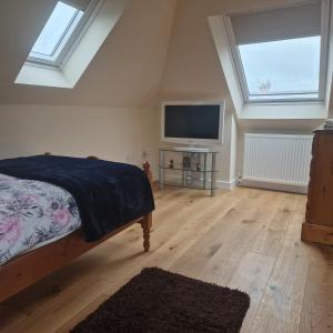 een slaapkamer met een bed en een flatscreen-tv bij 3 Bedroom Apartment max 5 Pax Musselburgh in Musselburgh