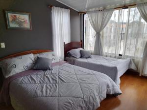 1 dormitorio con 2 camas y ventana en Habitación la Estación., en Paipa