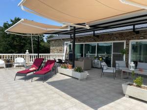 een patio met stoelen en een grote parasol bij Casa Acougo, Sarria in Sarria