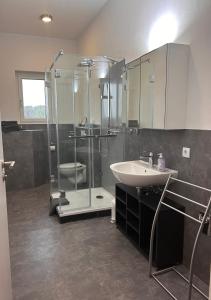 a bathroom with a glass shower and a sink at Moderne Maisonettewohnung/2 Zimmer/Küche/Bad #2 in Markt Schwaben