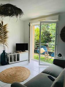 een woonkamer met een bank en een glazen schuifdeur bij Appartement cosy in Sarlat-la-Canéda