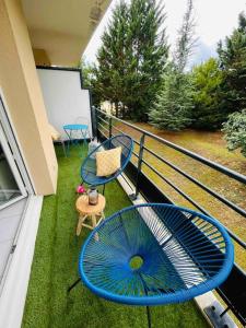 een balkon met 2 stoelen, een tafel en een scherm bij Appartement cosy in Sarlat-la-Canéda