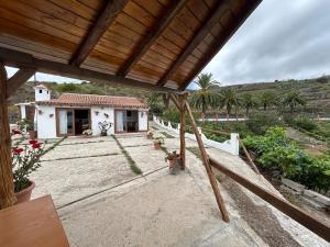 une maison avec vue sur une cour plantée de palmiers dans l'établissement Casa Rural Los Barros, à Genovés