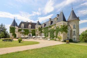 an old castle with turrets on a green lawn at H&ocirc;tel & SPA Ch&acirc;teau de La C&ocirc;te - Brant&ocirc;me in Biras