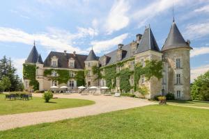 un antiguo castillo con torretas en un césped verde en Hôtel & SPA Château de La Côte - Brantôme, en Biras