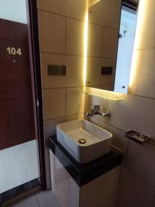 a bathroom with a white sink and a mirror at White Park Hotel & Suites in Chittagong