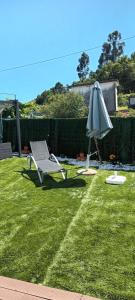 a chair and an umbrella on a lawn with a lawn at Alibaba do Gerês in Ruivães