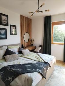a bedroom with a large bed and a mirror at Luxury Wide View Apartment Pohorje Bellevue in Pohorje