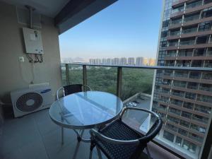 里约热内卢Via Premiere的一张玻璃桌子和椅子,位于公寓的阳台上