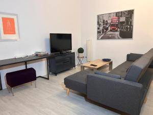 a living room with a couch and a television at Moderne Maisonettewohnung/2 Zimmer/Küche/Bad #2 in Markt Schwaben