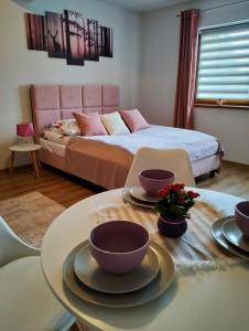sypialnia z łóżkiem i stołem z naczyniami w obiekcie Dębowy Apartamenty/Pokoje w mieście Dębno