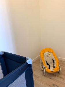 a yellow baby stroller sitting on a wooden floor at Charmante Villa in Châtellerault