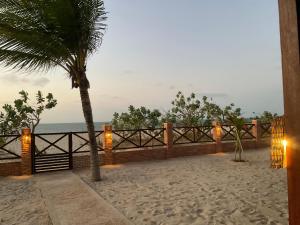 a view of the beach from a resort with a palm tree at BEACH HOUSE - Loggia Suite 3 - com cozinha - na praia - BEACHFRONT in Barra Grande
