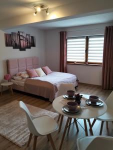 sypialnia z łóżkiem, stołem i krzesłami w obiekcie Dębowy Apartamenty/Pokoje w mieście Dębno