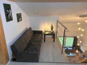 ein Wohnzimmer mit einem Sofa und einem Tisch in der Unterkunft Moderne Maisonettewohnung/2 Zimmer/Küche/Bad #2 in Markt Schwaben