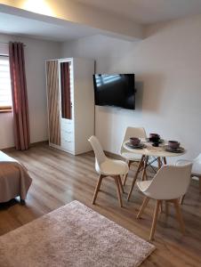 salon ze stołem, krzesłami i telewizorem w obiekcie Dębowy Apartamenty/Pokoje w mieście Dębno