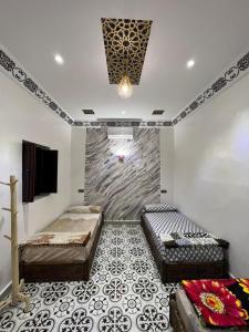Cette chambre comprend 2 lits et une télévision murale. dans l'établissement For You Riad Marrakech, à Marrakech