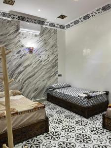 2 letti in una camera con parete in pietra di For You Riad Marrakech a Marrakech