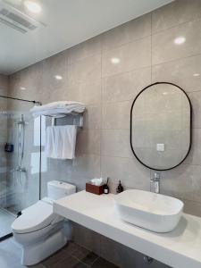 a bathroom with a sink and a toilet and a mirror at Muzhu B&B in Yilan City