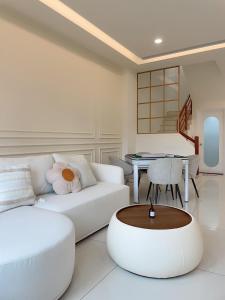 a living room with a white couch and a table at Muzhu B&B in Yilan City