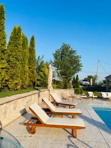 una fila de tumbonas junto a una piscina en Club12 pool house, en Čačak