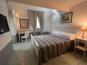 a bedroom with a bed and a desk and a television at Villa Maria Cristina in Santa Teresa Gallura