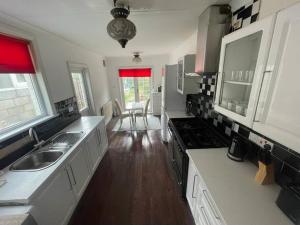 a kitchen with a sink and a stove top oven at 3-bedroom house - Thornton Heath in Thornton Heath