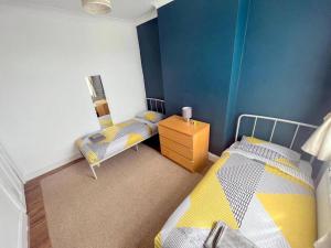 Cette petite chambre comprend deux lits. une table de nuit dans l'établissement 3-bedroom house - Thornton Heath, à Thornton Heath