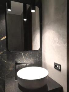 Un baño con un lavabo blanco y un espejo. en Apartment La Tonalina, en Passo del Tonale