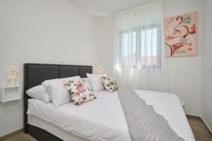 a white bed with two pillows on top of it at ZEN apartment - private pool in Trogir +30 photos