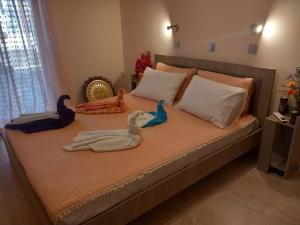 a bed with two swans and stuffed animals on it at Anemomylos House in Kámpos