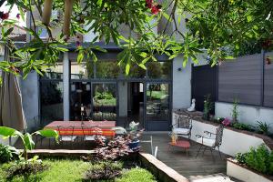 un patio con mesa y sillas en un jardín en Maison d'Hôtes " L'INSTANT D'AILLEURS" en Albi