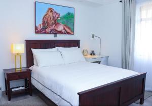 a bedroom with a bed with a painting of a lion at Rose Manor - Cozy Luxurious 2 Bedroom Apartment in Kilimani Nairobi in Nairobi
