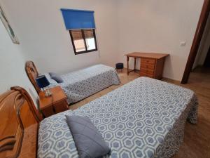 1 Schlafzimmer mit 2 Betten, einem Tisch und einem Fenster in der Unterkunft AT SAN PEDRO 2 in Olivenza