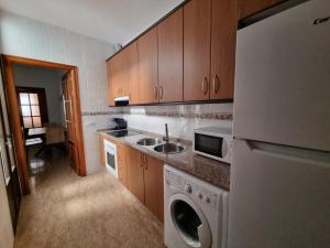 a kitchen with a refrigerator and a sink and a dishwasher at AT SAN PEDRO 2 in Olivenza