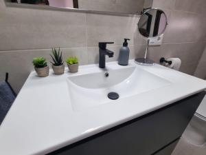 lavabo blanco en el baño con espejo en AT SAN PEDRO 2, en Olivenza