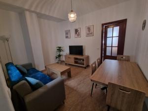 ein Wohnzimmer mit einem blauen Sofa und einem Tisch in der Unterkunft AT SAN PEDRO 2 in Olivenza